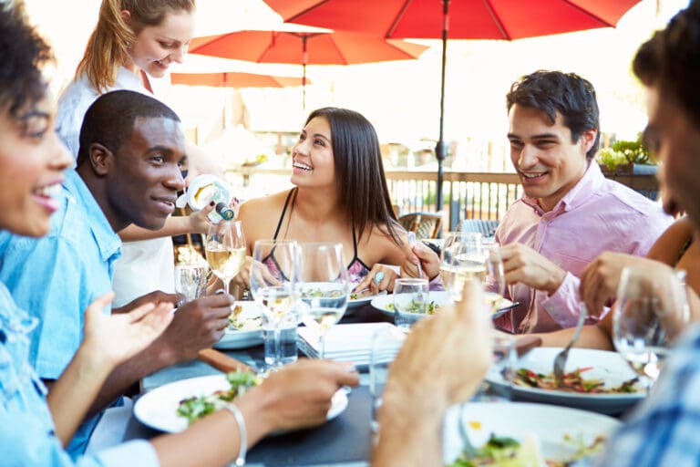 Group Of Friends Enjoying Meal At Outdoor Restaurant