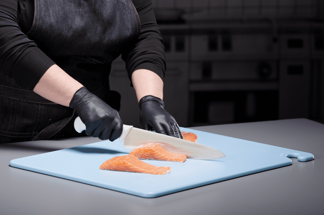 Chef Cutting Fish on Blue Board